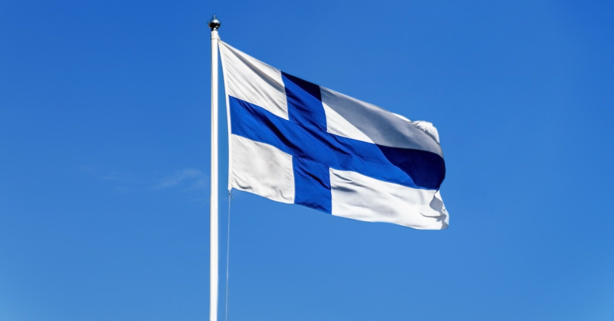 Suomen lippu salossa sinistä taivasta vasten.